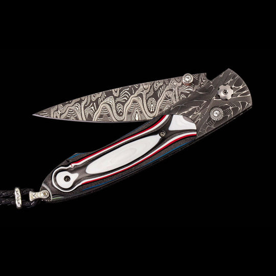 William Henry Knife
Knife Frame Type: hand-forged 'X-Out' damascus
Frame Engraver: Chad Nichols
Blade Type: hand-forged 'Hornets N
Scale/Inlay: ,inlaid with Fordite (aka 'Motor City Agate')
Number: 0.84/100
Gemstones/Embellishments: White Topaz