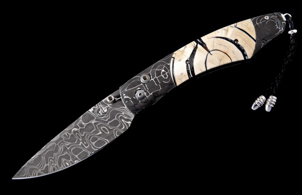 William Henry Knife
Knife Frame Type: etched ‘T-Rex’ damascus
Frame Engraver: Delbert Ealy
Blade Type: ‘Intrepid’ damascus
Damascus Artisan: Chad Nichols
Scale/Inlay: 10,000 year-old fossil Woolly Mammoth tusk
Number: 160/500
Gemstones/Embellishme